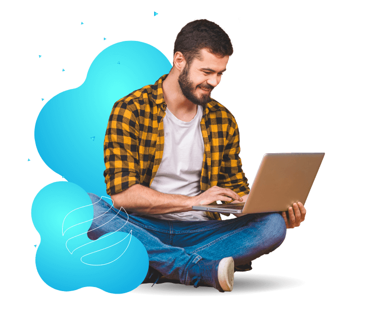 Homem sorridente sentado mexendo em um notebook.